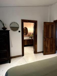 a bedroom with an open door and a mirror at Blackwoods FarmHouse in Beragala
