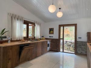 a large kitchen with wooden cabinets and a window at Blackwoods FarmHouse in Beragala