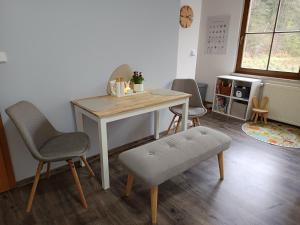 a table and chairs in a room with a desk at Apartmán 29 LANOVKA in Jáchymov
