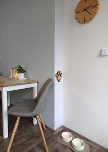 a chair sitting next to a desk with a clock at Apartmán 29 LANOVKA in Jáchymov +23 photos