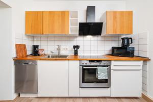 a kitchen with white cabinets and a sink and a microwave at Smart Home - Wuppertal - Perfect for 5 Guests! Netflix - Central - Smart TV - Free Parking Zone in Wuppertal