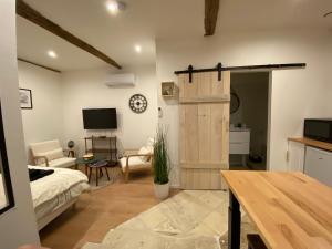 a living room with a bed and a wooden door at gite la Chauvinière 3 in Tonnay-Charente