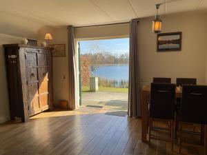 a dining room with a door open to a lake at Luxe villa aan het meer in Heel