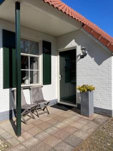 een huis met een bankje, een raam en een deur bij Luxe villa aan het meer in Heel