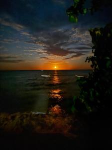 a sunset over the ocean with the sun in the distance at Guaecá Hostel - Cumuruxatiba in Cumuruxatiba