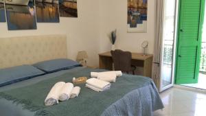 een slaapkamer met een bed, handdoeken en een bureau bij Vello Blu in Giovinazzo