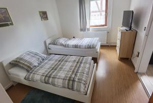 a room with two beds and a tv in it at Ferienwohnung am Backhaus 1 in Ahnatal