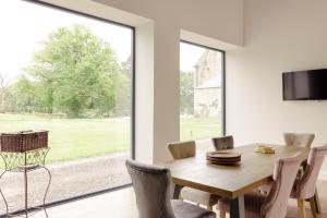 a dining room with a table and a large window at Elrick Estate - Coach House in Newmacher