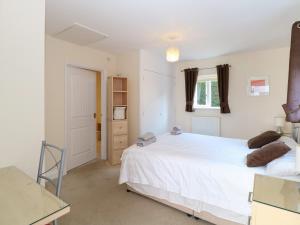 une chambre avec un lit blanc et une fenêtre dans l'établissement Rookyard Cottage, à Halesworth 20 autres photos