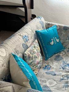 a couch with two blue pillows on it at Casa Rosa in Taquisara +105 photos