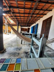 a hammock in a room with a building at Guaecá Hostel - Cumuruxatiba in Cumuruxatiba
