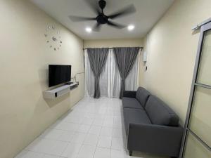 a living room with a couch and a ceiling fan at Qisa Guesthouse 03 in Arau