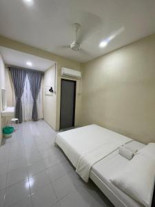 een slaapkamer met een groot wit bed in een kamer bij Qisa Guesthouse 03 in Arau