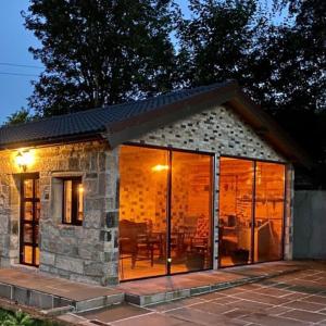 a stone cottage with sliding glass doors at The Owl Stony Snug in Carstairs Junction