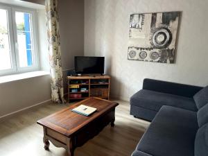 a living room with a couch and a coffee table at Maison à quelques mètres de la mer in Saint-Jean-du-Doigt