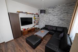 sala de estar con sofá negro y pared de ladrillo en Cozy flat in center of Bratislava, en Bratislava