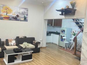 a living room with a couch and a table and a kitchen at Ting Ting Homestay in Hai Phong