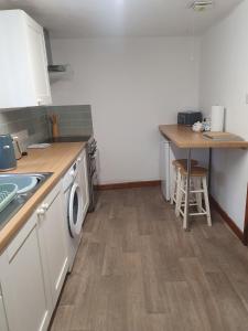 a kitchen with a sink and a washing machine at Cilgerran - cosy cottage in Cilgerran
