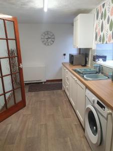 a kitchen with a sink and a washing machine at Cilgerran - cosy cottage in Cilgerran