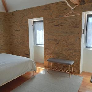 a bedroom with a bed and a chair in it at Casa do Faval in Senande