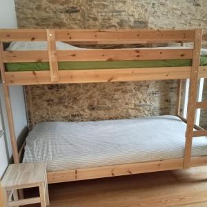 a bunk bed in a room with a brick wall at Casa do Faval in Senande +18 photos