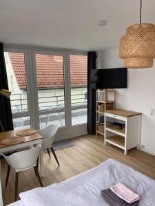 ein Schlafzimmer mit einem Bett, einem Tisch und einem Schreibtisch in der Unterkunft Apartment zentral in Gießen mit Balkon! in Gießen + 7 Fotos