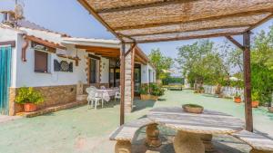 patio z drewnianym stołem i drewnianą pergolą w obiekcie Cortijo El Descanso Vélez Rubio by Ruralidays w mieście Vélez Rubio