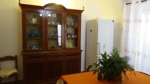 a large wooden cabinet in a kitchen with a table at XENIA Vacanze in Gallipoli