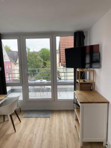 ein Wohnzimmer mit einem TV und einem großen Fenster in der Unterkunft Apartment zentral in Gießen mit Balkon! in Gießen