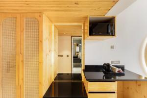 a kitchen with a black counter top and a microwave at Kyomi Retreat-Mukteshwar in Mukteswar