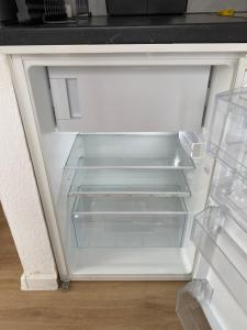 an empty refrigerator with its door open in a kitchen at Apartment zentral in Gießen mit Balkon! in Gießen