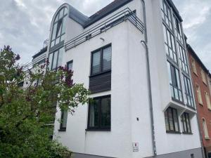 ein weißes Gebäude mit schwarzen Fenstern auf einer Straße in der Unterkunft Apartment zentral in Gießen mit Balkon! in Gießen