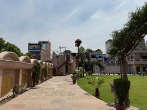 a walkway in a city with a lawn and buildings at Virasat Haveli in Varanasi +4 photos
