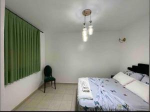 a bedroom with a bed and a chair and a window at Confortble 2Bedroom in Downtown in El Jadida