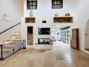 Una sala de estar con escalera y chimenea. en Villa Sienna à 10min de Cotignac, en Le Val