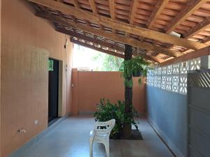 a white chair sitting on a porch with a tree at Plamary Recanto do Sossego, Casa 01 in Sinop