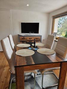 a dining room with a table with chairs and a television at Ferienwohnung Pfotenglück nahe Ostsee mit atemberaubender Dachterrasse & Gartenblick in Mallentin