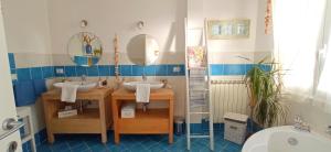 a bathroom with two sinks and two mirrors at Message in a Bottle Bed and Breakfast in Camporosso +37 photos