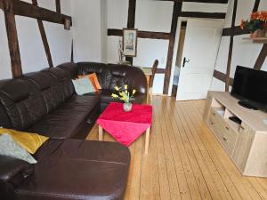 a living room with a leather couch and a table at Ferienwohnung Pastoriushaus in Bad Windsheim