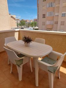 a white table and chairs on a balcony at Arenales Beach in Arenales del Sol