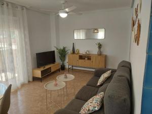 a living room with a couch and a tv at Arenales Beach in Arenales del Sol
