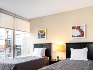 two beds sitting next to each other in a room at Luxury Apartment Downtown in Stamford