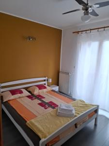 a bed in a bedroom with a ceiling fan at Apartman ENA in Opatija
