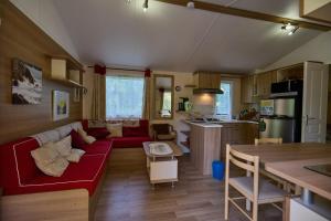 a living room with a red couch and a kitchen at Berges de Canal in Paule