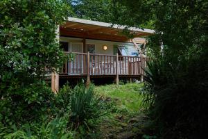 a small house with a porch and a deck at Berges de Canal in Paule