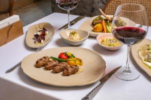 a table with plates of food and glasses of wine at Zafora Cave Suites Hotel Cappadocia in Uçhisar +143 photos