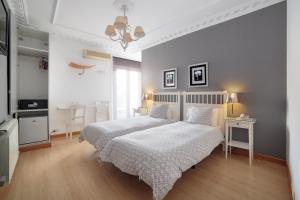 sypialnia z łóżkiem z białą narzutą w obiekcie Hostal Adriano w Madrycie