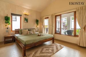 a bedroom with a bed and a large window at EKO STAY - Solace Villa I Charming Villa close to Candolim Beach in Candolim +22 photos