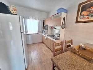 a kitchen with a refrigerator and a table in a room at Casa do Sid in Barra Velha +5 photos