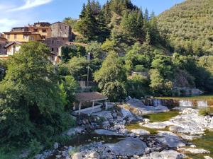 a river with a bench next to a mountain at CA DE MIN Haut de Villa à Badalucco in Badalucco